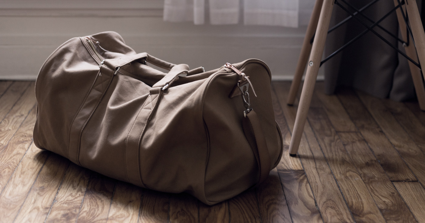 A duffle bag rests on the ground.