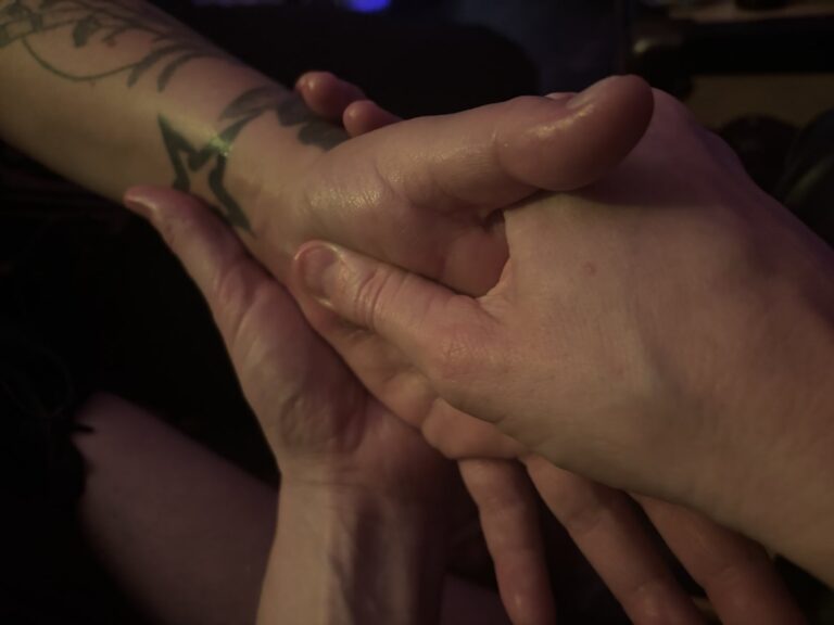 Kori holding and massaging the hand of a family member recovering from carpal tunnel surgery.